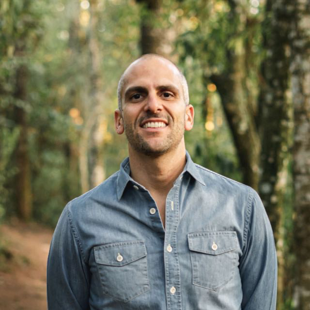 Ricardo Cury, professor de autoconhecimento e meditação, sorrindo em meio à natureza